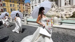 Para perempuan yang upacara pernnikahannya ditunda atau dibatalkan akibat pandemi covid-19 melakukan protes di Trevi Fountain, Roma, Selasa (7/7/2020). Mereka memprotes kebijakan pemerintah Italia yang masih melarang adanya acara pernikahan, meski lockdown sudah dilonggarkan. (AP/Riccardo De Luca)
