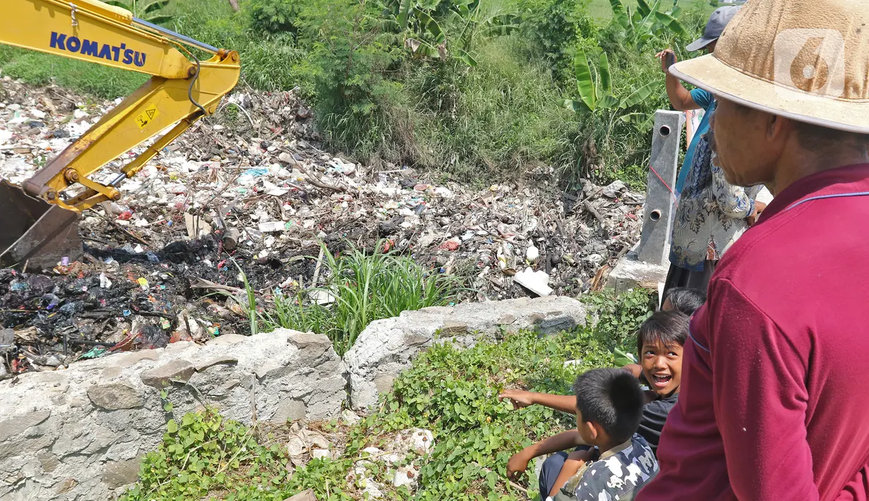Anak-anak menyaksikan ekskavator mengeruk sampah yang memenuhi Kali Busa di Tambun Utara, Kabupaten Bekasi, Jawa Barat, Jumat (10/9/2021). Pengerukan sampah ditargetkan selesai selama dua hari dan selanjutnya dipindahkan ke TPA Burangkeng. (Liputan6.com/Herman Zakharia)