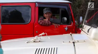 Sopir jeep menunggu wisatawan yang akan melanjutkan perjalanan ke Gunung Bromo di Kecamatan Tosari, Pasuruan, Jawa Timur, Sabtu (4/11). Mobil ini mampu membawa 5 penumpang. (Liputan6.com/Fery Pradolo)