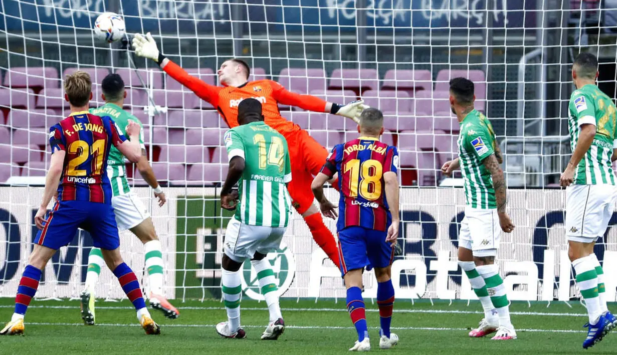 Kiper Barcelona, Marc-Andre ter Stegen, berusaha menghalau bola saat pertandingan melawan Real Betis pada laga La Liga di Stadion Camp Nou, Sabtu (7/11/2020). Barca menang dengan skor 5-2.(AP/Joan Monfort)