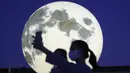 Warga berswafoto dekat instalasi bulan purnama yang bersinar di sebuah taman di Seoul, Korea Selatan, Jumat (18/9/2020). Pejabat setempat memasang bulan purnama buatan untuk meningkatkan semangat saat wabah COVID-19 sekaligus menyambut Chuseok, Thanksgiving versi Korea. (AP Photo/Ahn Young-joon)