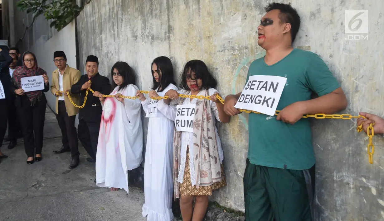 Sejumlah karyawan Star Hotel Semarang mengadakan teatrikal 'merantai setan' di parkiran bawah hotel, Selasa (15/5). Aksi menyambut bulan Ramadan tersebut memiliki filosofi setan yang “dikerangkeng” dan dijauhkan dari para hamba-Nya. (Liputan6.com/Gholib)