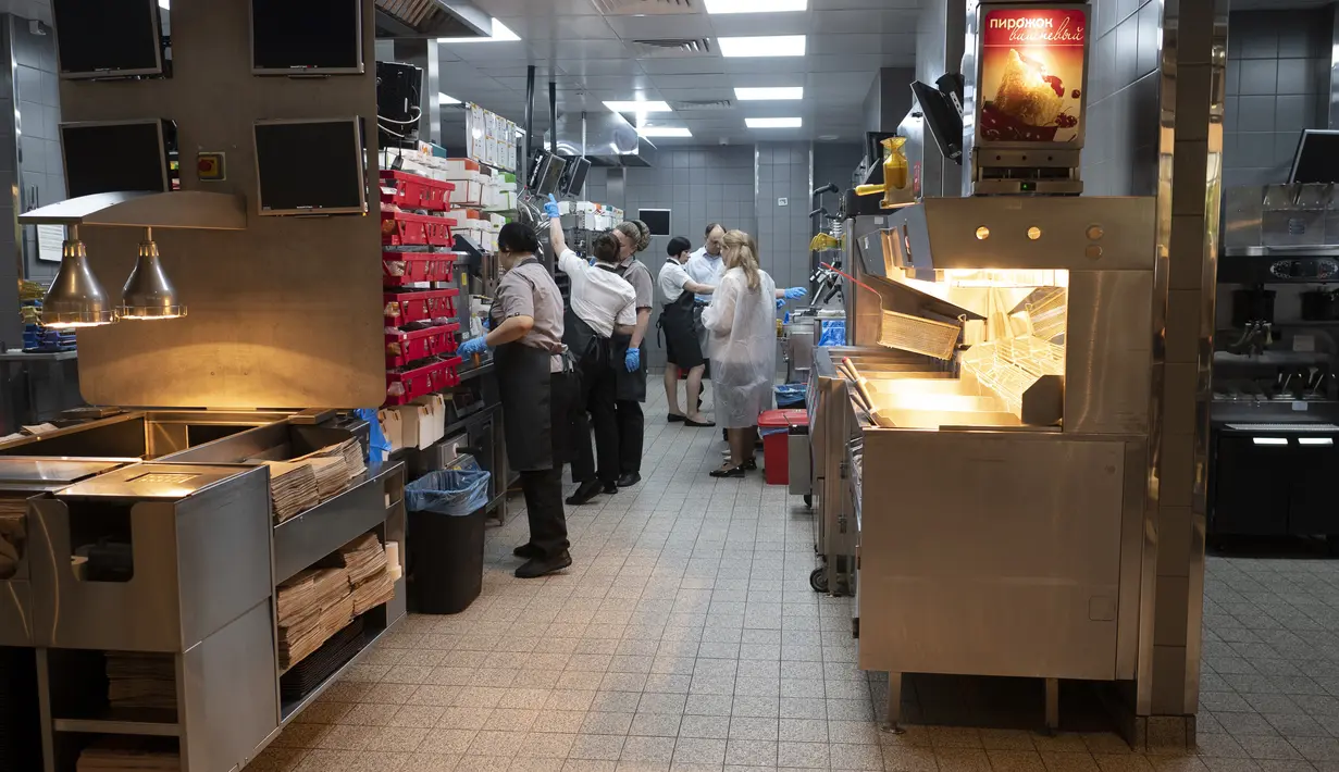 Pekerja bekerja di dapur sebuah restoran cepat saji yang baru dibuka di bekas gerai McDonald's di Bolshaya Bronnaya Street, Moskow, Rusia, 12 Juni 2022. Restoran pengganti McDonald's pertama dibuka di Moskow dengan mereka baru. (AP Photo/Dmitry Serebryakov)