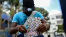 Wilmer Rojas (25) saat membuat tas dari lembaran mata uang Bolivar di Caracas, Venezuela, 30 Januari 2018. Lembaran uang tersebut kini tidak lagi menjadi alat jual beli, melainkan bahan untuk membuat kerajinan tangan. (AFP Photo/Federico Parra)