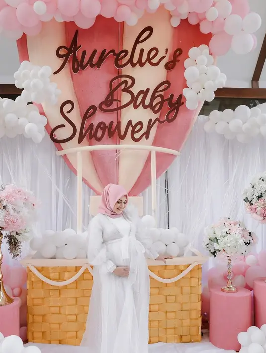 Aksen pita dan warna hijab dusty pink yang kontras, membuat tampilan Aurel terlihat memikat dan semakin glowing, jelang kelahirannya.