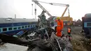 Petugas penyelamat mencari korban di antara bangkai kereta api setelah terjadi kecelakaan di Pukhrayan, Kanpur, India (21/11). Kebanyakan korban terjebak karena masih tertidur saat kereta mengalami kecelakaan pada pagi hari. (Reuters/ Jitendra Prakash)