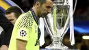 Gianluigi Buffon melintas dekat trofi Liga Champions, Juventus gagal merebut trofi tersebut setelah kalah dari Real Madrid 1-4. di Millennium Stadium, Cardiff, Wales (3/6/2017). (Nick Potts/PA via AP)