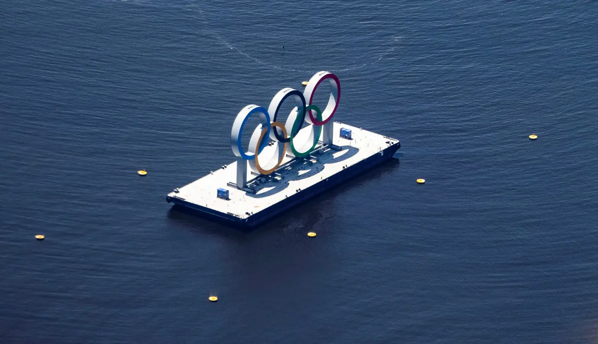 Foto udara ini menunjukkan cincin Olimpiade di tepi pantai Odaiba di Tokyo, saat kota tersebut bersiap menjadi tuan rumah Olimpiade 2020, pada 19 Juli 2021. Olimpiade Tokyo 2020 digelar mulai 23 Juli 2021, mundur setahun dari agenda semula akibat pandemi virus corona Covid-19. (Yuki IWAMURA/AFP)