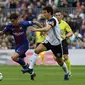 Gelandang Barcelona Philippe Coutinho (kiri) melewati penjagaan kapten Valencia, Dani Parejo, pada pertandingan di Camp Nou, Sabtu (14/4/2018). (AFP/Lluis Gene)