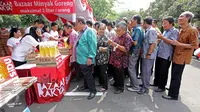 Pegawai antri untuk membeli minyak goreng murah Bazar Rakyat di lapangan parkir Kemenlu, Jakarta. (19/08). Sekitar 2.000 liter minyak goreng kemasan seharga Rp 7.000 per liter disalurkan bagi keluarga besar Kemenlu. (Liputan6.com/Angga Yuniar)