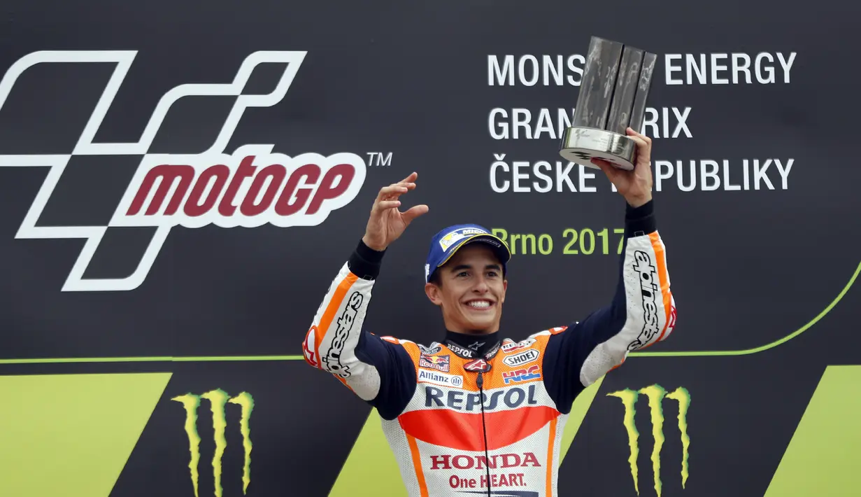 Marc Marquez mengangkat trofi juara usai mengalahkan para pebalap lainya pada balapan MotoGP Republik Ceska di Sirkuit Brno, (6/8/2017). (AP/Petr David Josek)