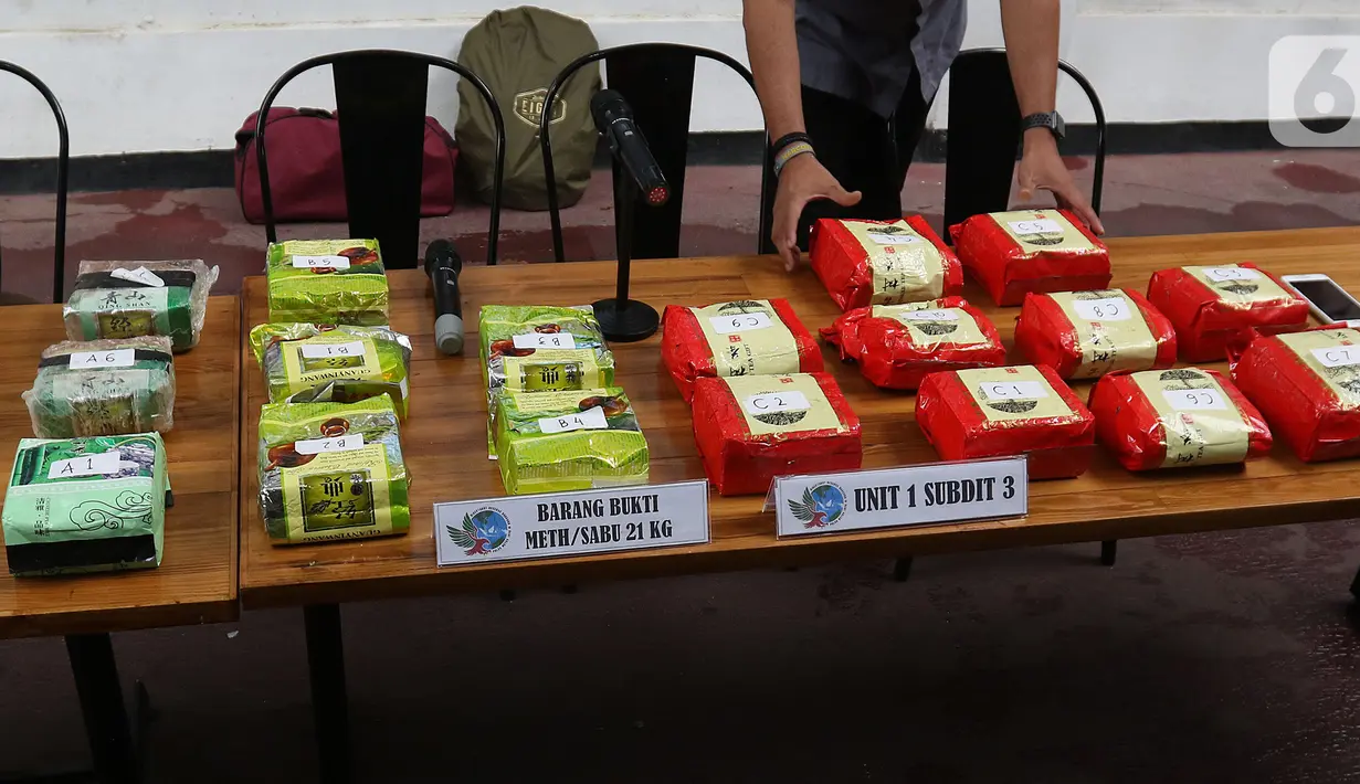Petugas merapikan barang bukti saat rilis pengungkapan kasus penyelundupan sabu-sabu di Polda Metro Jaya, Jakarta, Jumat (1/11/2019). Polda Metro Jaya menangkap lima tersangka jaringan Malaysia-Indonesia penyelundup sabu-sabu seberat 21 kg. (Liputan6.com/Herman Zakharia)