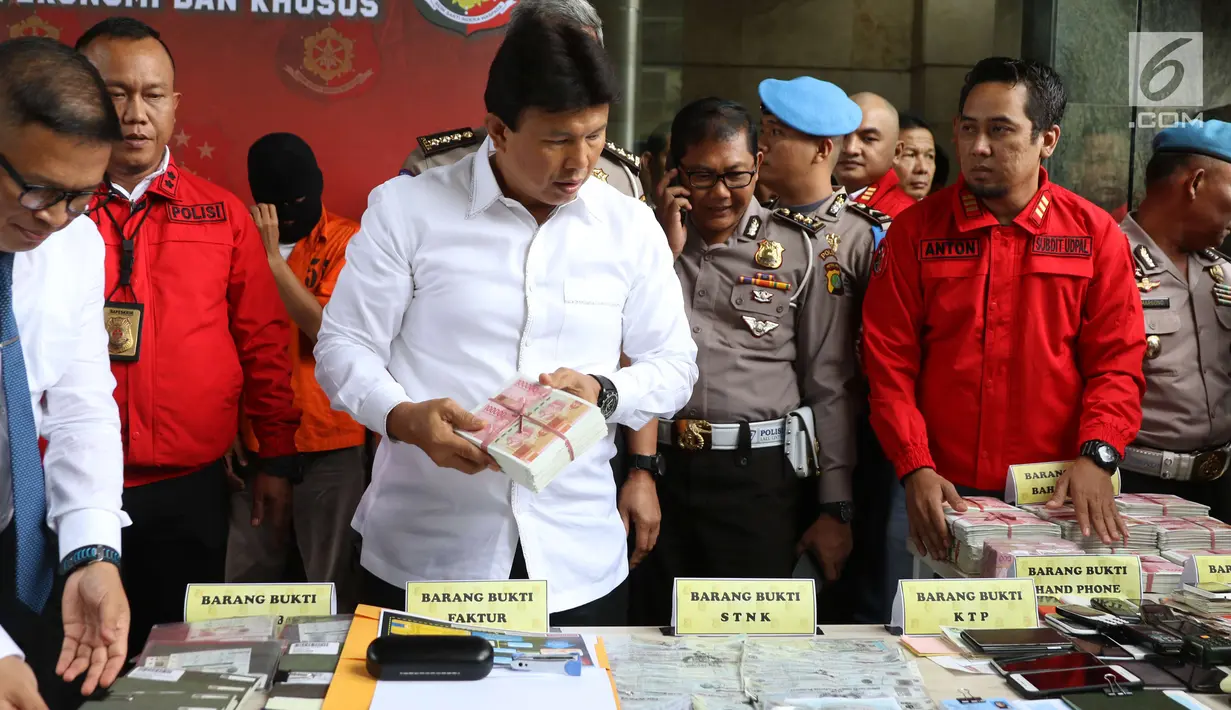 Kabareskrim Komjen Ari Dono memeriksa barang bukti kasus pemalsuan dokumen dan uang palsu dalam rilis di Jakarta, Rabu (20/12). Polisi menangkap 13 tersangka yang mulai beroperasi sejak 2014 di wilayah Jakarta dan Jawa Barat. (Liputan6.com/Angga Yuniar)