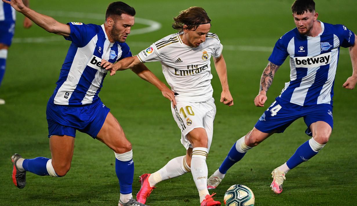Gelandang Real Madrid, Luka Modric, berebut bola dengan penyerang Alaves, Lucas Perez, pada laga lanjutan La Liga pekan ke-35 di Stadion Alfredo di Stefano, Sabtu (11/7/2020) dini hari WIB. Real Madrid menang 2-0 atas Alaves. (AFP/Gabriel Bouys)