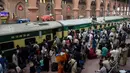 Para pelancong berebut memasuki pintu gerbong kereta saat mudik menuju kampung halaman untuk merayakan Idul Adha di stasiun Lahore, Pakistan, Sabtu (10/8/2019). Umat Islam di seluruh dunia merayakan Idul Adha yang identik dengan tradisi berkurban. (Photo by ARIF ALI / AFP)