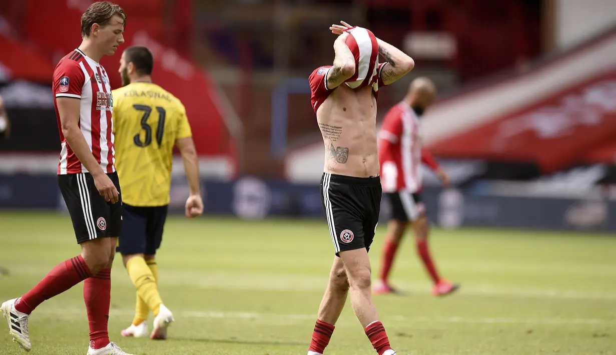 Pemain Sheffield United Oliver McBurnie (kanan) bereaksi usai kalah dari Arsenal pada putaran keenam Piala FA di Bramall Lane, Sheffield, Inggris, Minggu (28/6/2020). Arsenal melaju ke semifinal Piala FA usai menaklukkan Sheffield United 2-1. (Oli Scarff/Pool via AP)