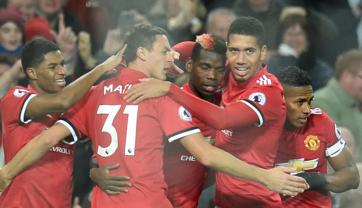 Gelandang Manchester United Paul Pogba bersama rekan setimnya merayakan gol ke gawang Newcastle United pada laga lanjutan Premier League pekan ke-12 di Old Trafford, Minggu (19/11). MU menang telak 4-1 atas Newcastle. (Oli SCARFF / AFP)