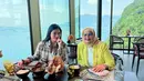 Titi Kamal bersama sang mama saat menikmati makan siang dengan latar belakang keindahan pemandangan sungai dan gunung di Swiss. (instagram/titi_kamall)