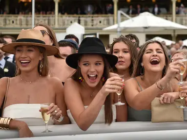 Sejumlah wanita bersorak saat menyaksikan pacuan kuda Everest 2017 di Royal Randwick di Sydney, Australia (14/10). Para wanita ini tampil cantik dengan busana yang dikenakannya . (AFP Photo/Peter Parks)