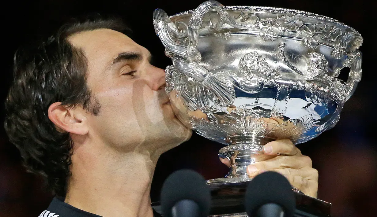 Petenis asal Swiss Roger Federer, mencium trofinya setelah berhasil meraih gelar Australia Terbuka 2017 di Melbourne, Minggu (29/1). Federer juga mencatatkan rekor sebagai petenis tertua yang memenangkan Grand Slam di usia 35 tahun (AP Photo/Aaron Favila)
