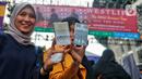 Penggemar Westlife menunjukkan album dalam bentuk fisik kaset tape saat tiba untuk menonton konser bertajuk 'The Wild Dreams Tour 2023' di kawasan Stadion Utama Gelora Bung Karno Sabtu (11/2/2023). Konser musik Westlife akan membawakan semua lagu hits mereka seperti Swear It Again, Flying Without Wings, dan World of our own serta lagu-lagu andalan dari album terbaru mereka yang bertajuk Wild Dreams. (Liputan6.com/Angga Yuniar)