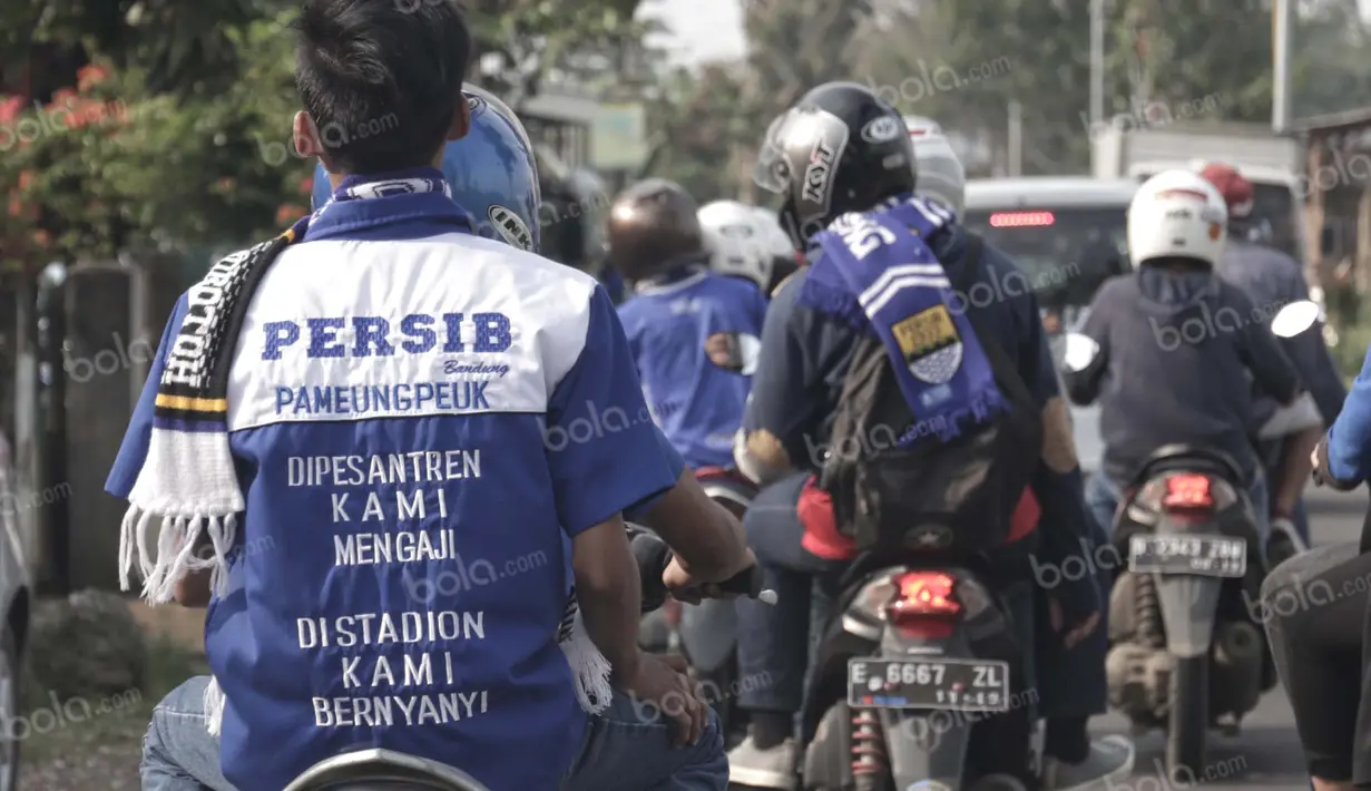Tulisan dukungan unik tertulis di kemeja salah satu fans Maung Bandung yang berkendaraan motor menuju Stadion Si Jalak Harupat, Soreang, Bandung, Rabu (30/3/2016). Mereka ingin menyaksikan duel Persib vs Bali United.(Bola.com/Nicklas Hanoatubun).