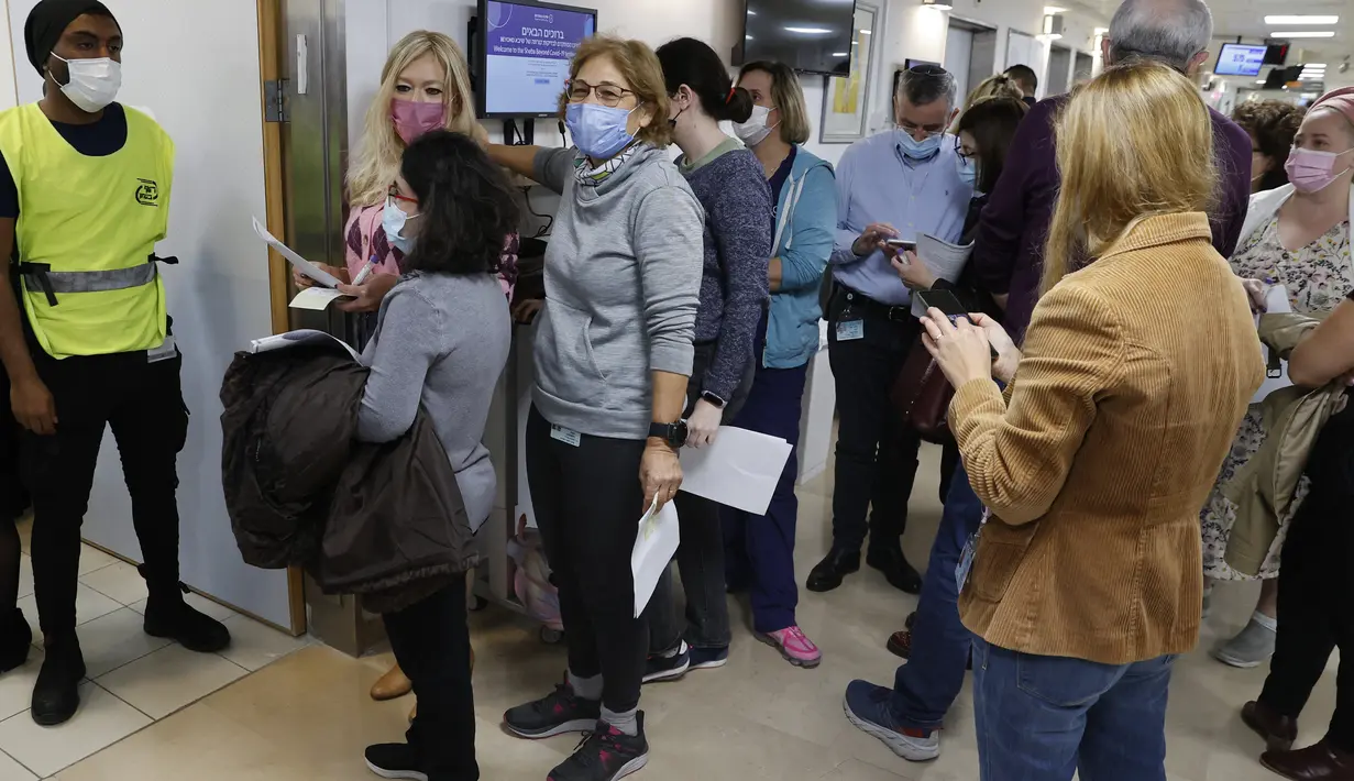 Staf sukarelawan antre untuk menerima dosis keempat vaksin covid-19 Pfizer-BioNTech di Sheba Medical Center di Ramat Gan dekat Tel Aviv, Senin (27/12/2021). Pemberian suntikan ini bertujuan untuk mengukur apakah suntikan penguat (booster) kedua diperlukan secara nasional. (AP Photo/Tsafrir Abayov)