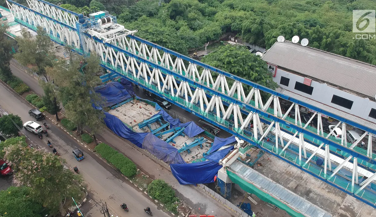 Suasana dari ketinggian konstruksi tiang beton Light Rail Transit (LRT) yang roboh di Kayu Putih, Jakarta Timur, Senin (22/1). Beton konstruksi LRT antarspan P28 dan P29 yang ambruk ditutupi terpal biru. (Liputan6.com/Arya Manggala)