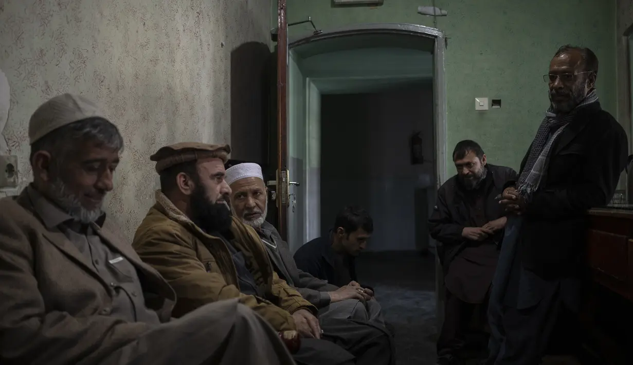 Anggota staf duduk di dalam kantor tiket Bioskop Ariana di Kabul, Afghanistan pada 8 November 2021. Mereka masih muncul di tempat kerja setiap hari berharap pada akhirnya akan dibayar, meskipun ada perintah Taliban untuk berhenti beroperasi. (AP Photo/Bram Jansen)
