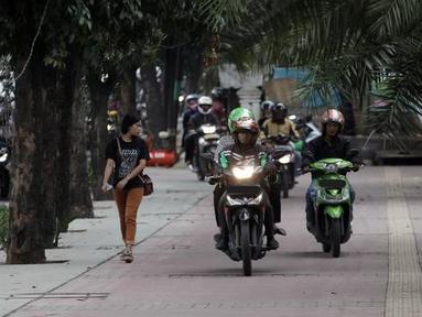 Gerombolan pemotor berjalan di atas trotoar sehingga pejalan kaki harus mengalah ke pinggir. (Source: liputan6.com)