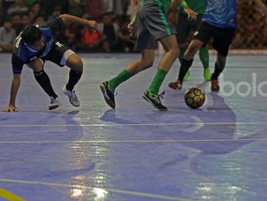 Pemain Timnas Futsal Indonesia, Reza Yamani (tengah) mencoba melewati para pemain BJL 2000 pada laga Uji Coba di Lapangan Futsal Tifosi Sport Center, Jakarta, (14/1/2017). Timnas menang 7-5. (Bola.com/Nicklas Hanoatubun)