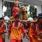 Warga menampilkan tarian Sisingaan Subang saat melakukan karnaval di jalan Pintu 1 Senayan, Jakarta, Minggu (24/9). Karnaval tersebut dilakukan dalam rangka HUT Gelora Bungkarno yang ke-55. (Liputan6.com/Angga Yuniar)