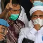 Rizieq Shihab (tengah) memberi keterangan sesaat sebelum masuk gedung utama Mapolda Metro Jaya, Jakarta, Sabtu (12/12/2020). Rizieq Shihab akan menjalani pemeriksan sebagai tersangka penghasutan dan kerumunan di tengah pandemi Covid-19. (Liputan6.com/Helmi Fithriansyah)