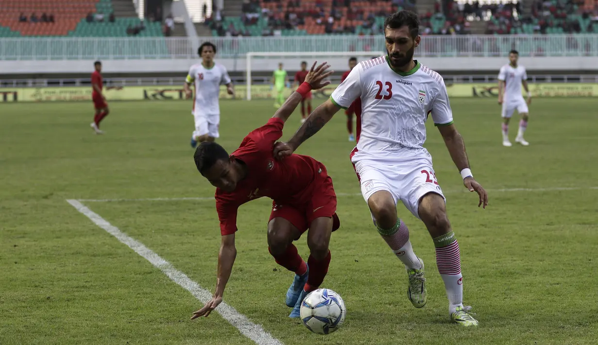 Gelandang Timnas Indonesia U-22, Sani Rizki, berebut bola dengan pemain Timnas Iran U-23 pada laga uji coba internasional di Stadion Pakansari, Bogor, Sabtu (16/11). Indonesia menang 2-1 atas Iran. (Bola.com/Yoppy Renato)
