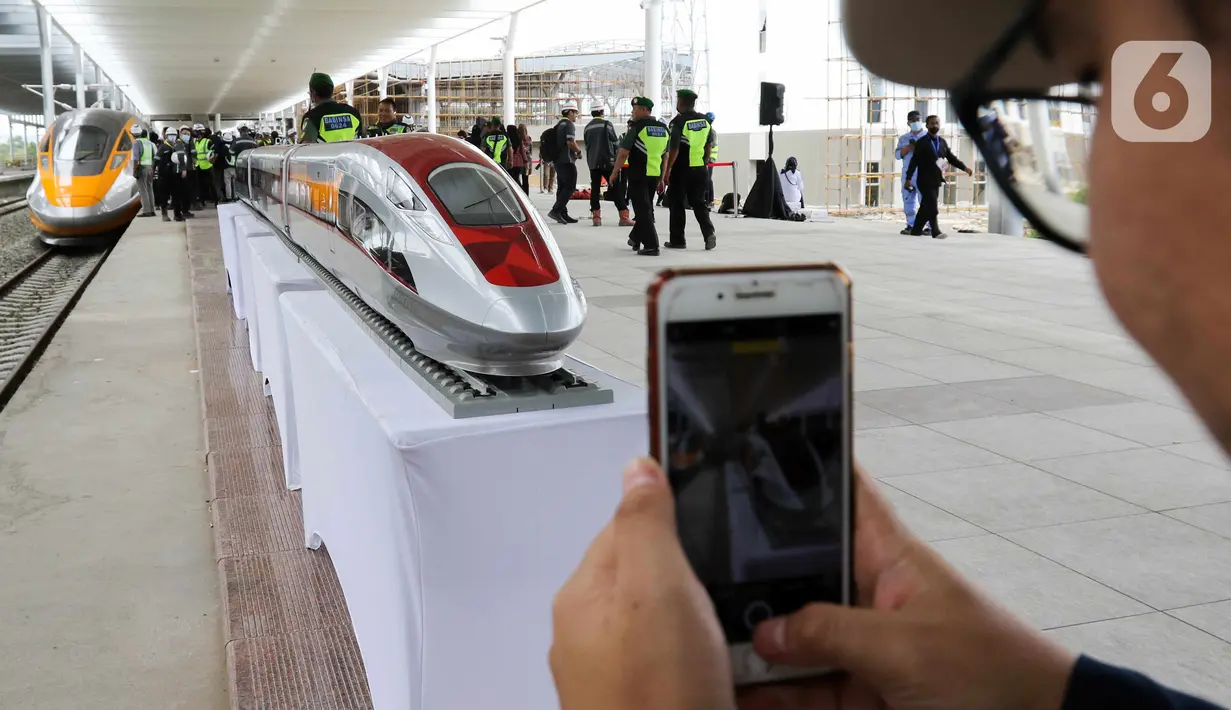 Seseorang mengambil gambar rangkaian kereta cepat di Stasiun Tegalluar, Kabupaten Bandung, Jawa Barat, Kamis (13/10/2022). Progres pembangunan proyek Kereta Cepat Jakarta-Bandung telah mencapai 88,8 persen dan direncanakan beroperasi pada Juli 2023. (Liputan6.com/Herman Zakharia)