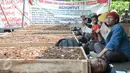 Petani wanita menunggu anaknya yang dikubur saat aksi di halaman Monas, Jakarta, Senin (1/5). Aksi kubur diri dilakukan untuk mendapat perhatian pemerintah terkait konflik agraria di Telukjambe, Karawang. (Liputan6.com/Yoppy Renato)