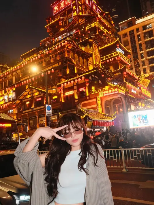 Outer bergaya cardigan rajut berwarna abu-abu muda yang disampirkan menambah sentuhan cozy, sangat cocok untuk suasana malam yang sejuk di tengah hiruk pikuk kota. [@fuji_an].