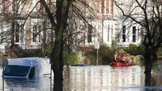 Tim regu penyelamat menyisir lokasi pemukiman warga yang terendam banjir menggunakan perahu karet di York, Inggris utara, Minggu (27/12). Banjir akibat luapan sungai Ouse yang telah memperburuk sejumlah wilayah Inggris utara. (REUTERS/Phil Noble)