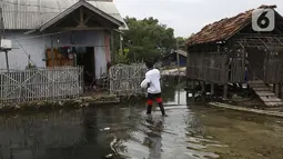 Jurnalis menyalurkan bantuan sembako di Pulau Panjang, Serang, Banten, Sabtu (30/1/2021). Bantuan sembako dan uang tunai bagi warga kurang mampu diberikan karena menurunnya daya beli masyarakat untuk mengonsumsi ikan turun akibat pandemi Covid-19. (Liputan6.com/Pool/JP)