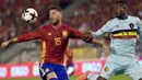 Bek Spanyol, Sergio Ramos, berusaha menahan pergerakan striker Belgia, Divock Origi. Spanyol menguasai jalannya laga dengan penguasaan bola 61 persen. (Reuters/Eric Vidal)