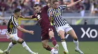 Pemain Torino, Alessandro Buongiorno, berduel dengan gelandang Juventus, Adrien Rabiot, dalam laga Derby della Mole melawan Torino di Olimpico Grande Torino Stadium, Sabtu (13/4/2024) malam WIB. Laga derbi itu berakhir imbang tanpa gol. (Fabio Ferrari/LaPresse via AP)