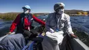 Petugas kesehatan diantar ke pulau Uros untuk menyuntik warga dengan vaksin COVID-19 Sinopharm, di danau Titicaca di Puno, Peru, pada 7 Juli 2021. Peru memulai vaksinasi COVID-19 untuk ratusan penduduk asli yang tinggal di pulau terapung Uros, di Danau Titicaca. (Carlos MAMANI / AFP)