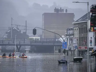 Warga menggunakan rakit karet di tengah banjir setelah Sungai Meuse jebol saat banjir besar di Liege, Belgia, Kamis (15/7/2021). Curah hujan yang tinggi menyebabkan banjir di beberapa provinsi di Belgia dengan hujan diperkirakan berlangsung hingga Jumat. (AP Photo/Valentin Bianchi)