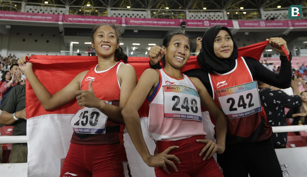 Pelari Indonesia, Putri Aulia, Ni Made Arianti, Endang Sari Sitorus, melakukan selebrasi usai menjuarai lari 100M T13 pada Asian Para Games di SUGBK, Jakarta, Rabu (10/10/2018). Indonesia meraih memborong tiga mendali. (Bola.com/M Iqbal Ichsan)