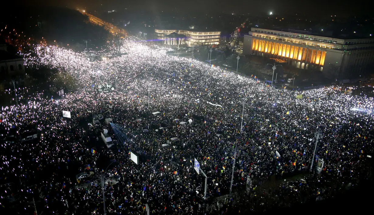 Pengunjuk rasa berkumpul di pusat Bucharest merayakan kemenangan tuntutan mereka, Rumania, Minggu (5/2). Pengunjuk rasa menuntut Pemerintah Rumania untuk membatalkan UU Korupsi. (AP Photo)
