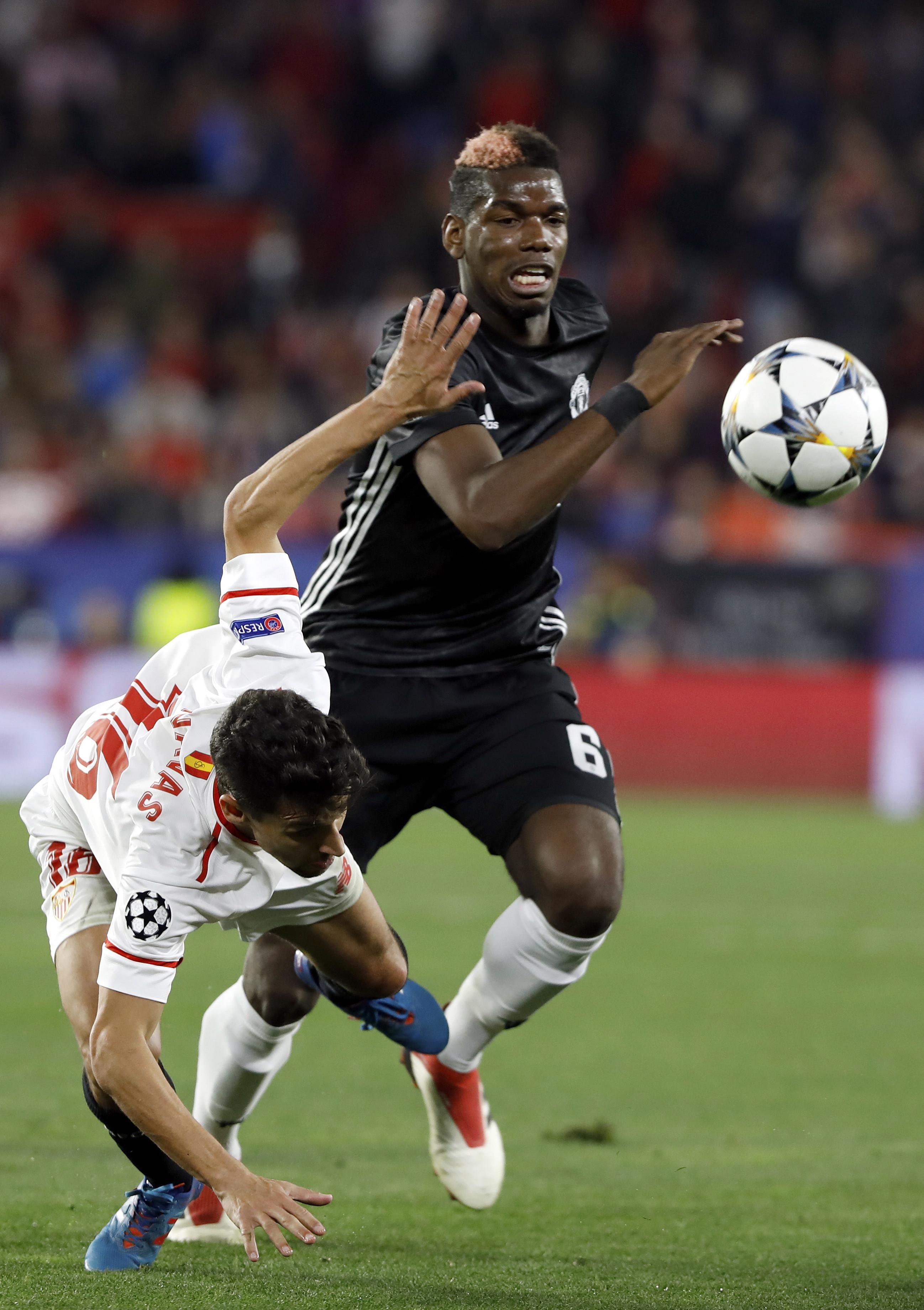Aksi pemain Manchester United, Paul Pogba (kanan) saat berebut bola dengan pemain Sevilla, Jesus Navas pada laga 16 besar Liga Champions di Ramon Sanchez Pizjuan stadium, Seville, (21/2/2018). (AP/Miguel Morenatti)