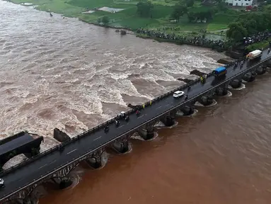 Salah satu dari dua jembatan utama yang menghubungkan kota Mumbai dengan negara bagian Goa di barat India runtuh di atas Sungai Savitri, Rabu (3/8). Dua bus yang membawa sedikitnya 22 penumpang terjun ke sungai berarus deras akibat hujan lebat. (AFP)