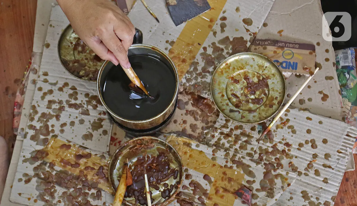 Perajin menyelesaikan salah satu tahapan produksi batik Marunda di Rusunawa Marunda, Jakarta, Selasa (14/7/2020). Kreasi para ibu tersebut dilakukan mulai dari Senin hingga Kamis. (Liputan6.com/Herman Zakharia)