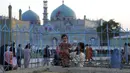 Seorang anak berpose untuk difoto saat mengunjungi Hazrat-e-Ali atau Masjid Biru di Mazar-e-Sharif, Afghanistan, Rabu (7/7/2021). Masjid Biru adalah tempat yang diminati orang-orang untuk menikmati ketenangan dari hiruk jalanan dan keramaian aktivitas pasar. (AP Photo/Rahmat Gul)