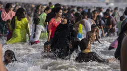 Pengunjung memadati pantai Juhu di Laut Arab pada hari yang panas dan lembab di kota Mumbai, India, 8 Mei 2022. Tingginya suhu udara diperparah dengan kurangnya curah hujan. Maret lalu tercatat sebagai bulan terpanas di India sejak 122 tahun lalu. (AP Photo/Rafiq Maqbool)